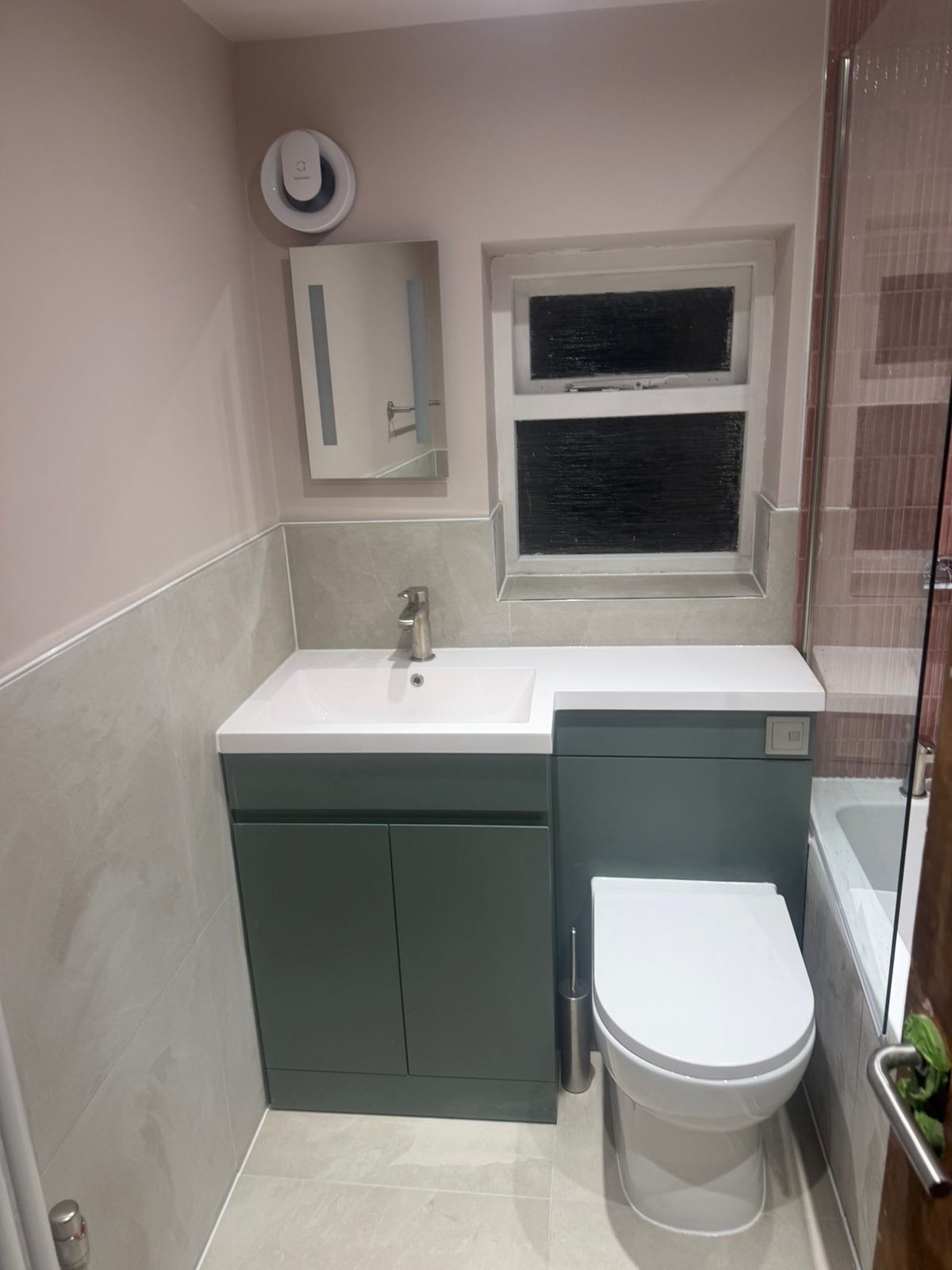 Compact bathroom with green vanity and white suite