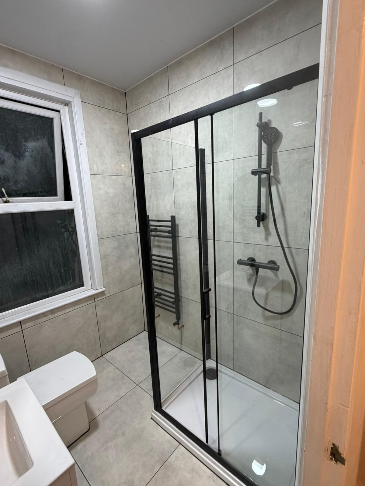 Grey-tiled shower enclosure with chrome fittings