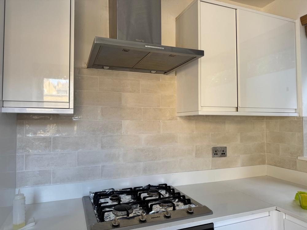 Grey handleless kitchen with black tap