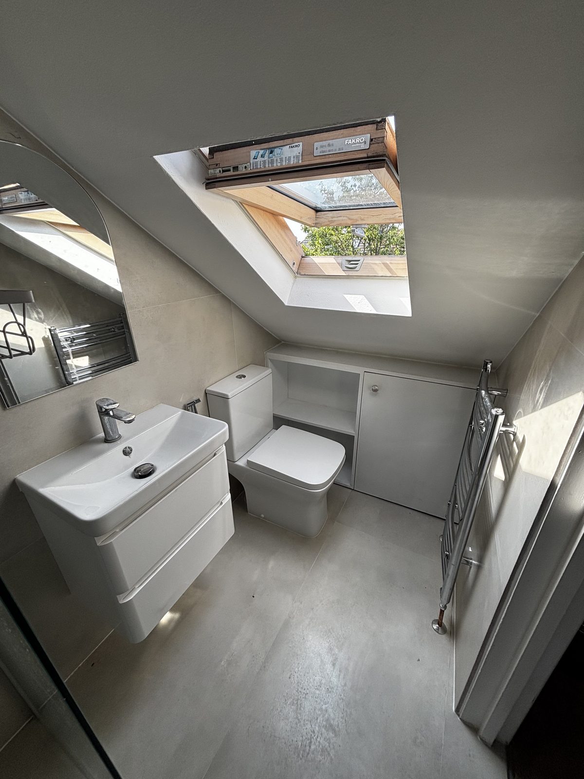 Loft ensuite with wall-hung vanity, skylight and bespoke storage
