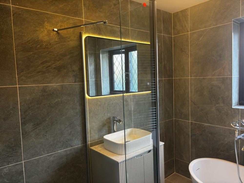 Slate-tiled bathroom with LED mirror, fluted vanity and walk-in shower