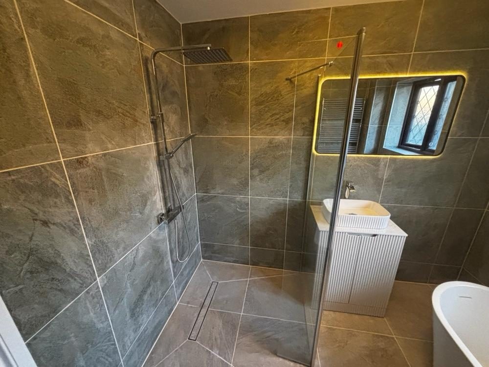 Slate walk-in wet room with rainfall shower and glass screen